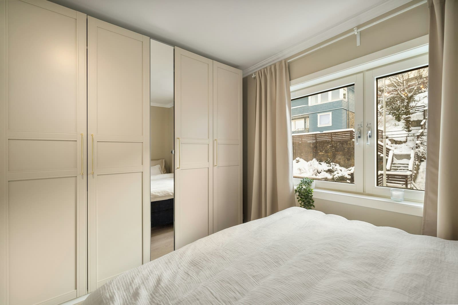 Kast wrappen: inbouwkast met gladde lichte fronten in de slaapkamer